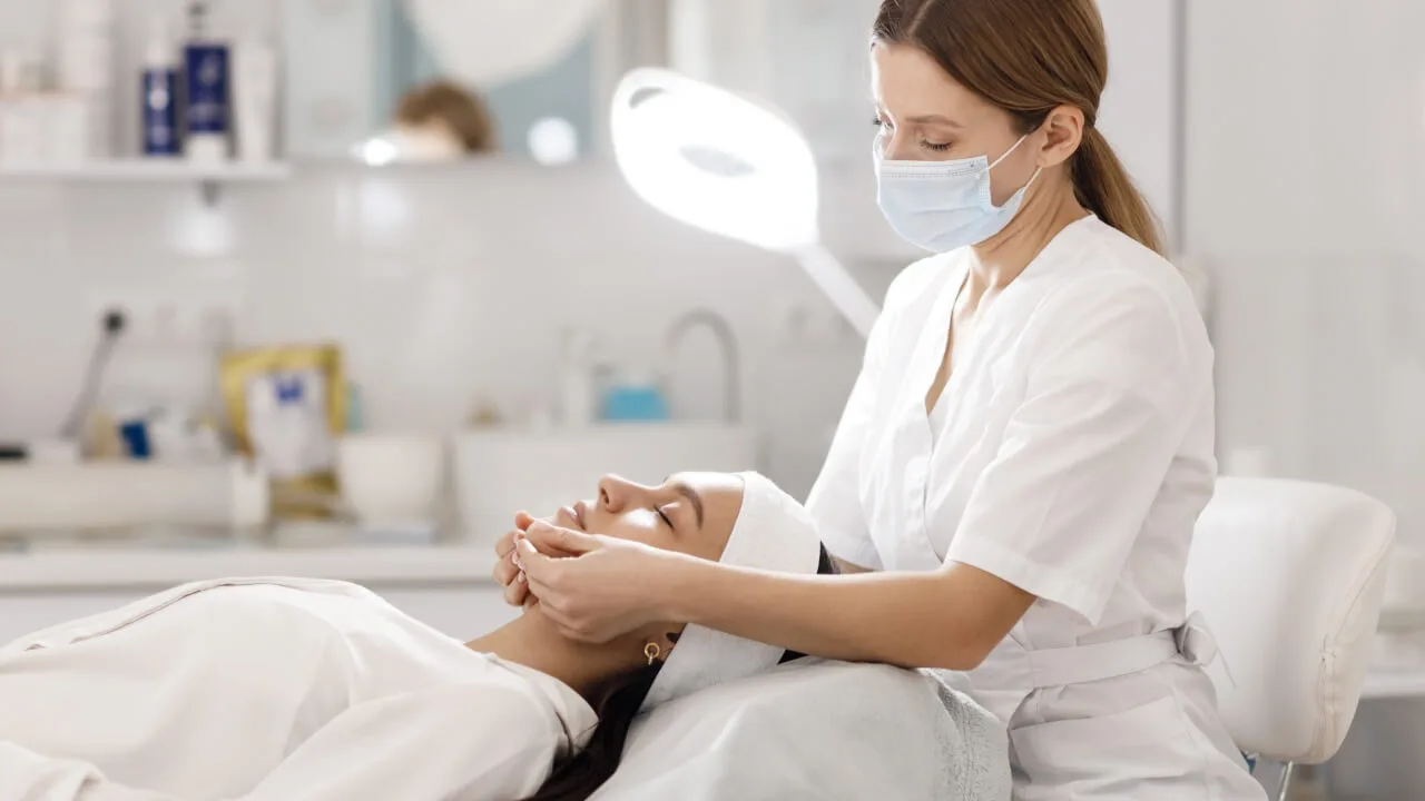 Mulher deitada com profissional fazendo harmoniza&ccedil;&atilde;o facial