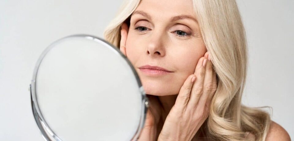 caroline antunes dermatologia mulher se olhando no espelho